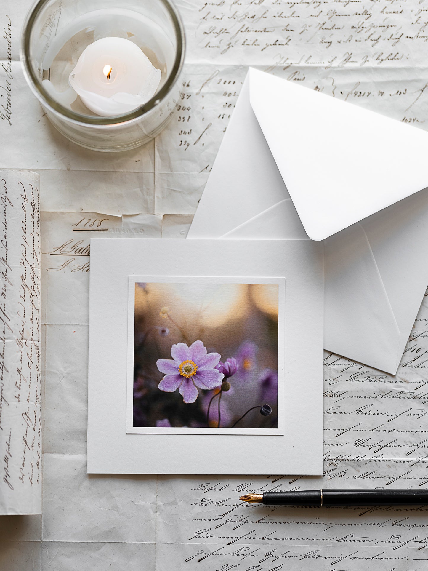 Handgefertigte Beileidskarte mit zarter rosa Anemonen-Blüte im goldenen Licht